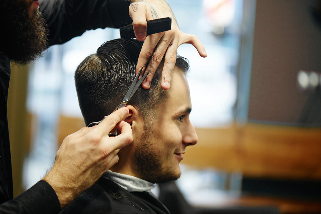 An old school Barber cutting a customers hair